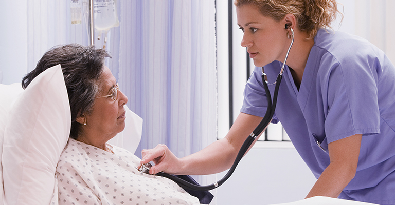 A imagem mostra uma enfermeira medindo os batimentos cardíacos de uma paciente